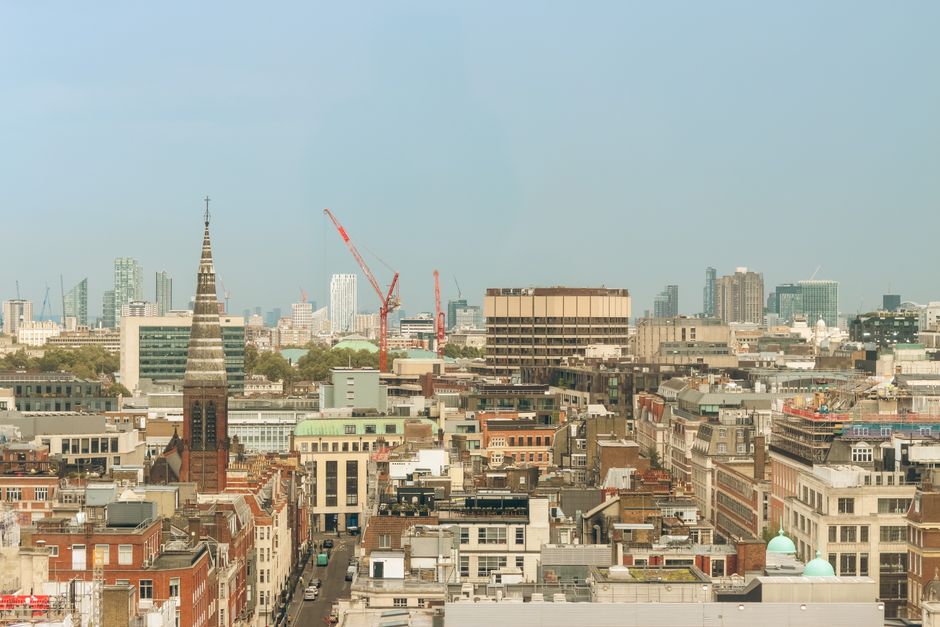 Aerial view of London showcasing historic and modern architecture under a clear sky.