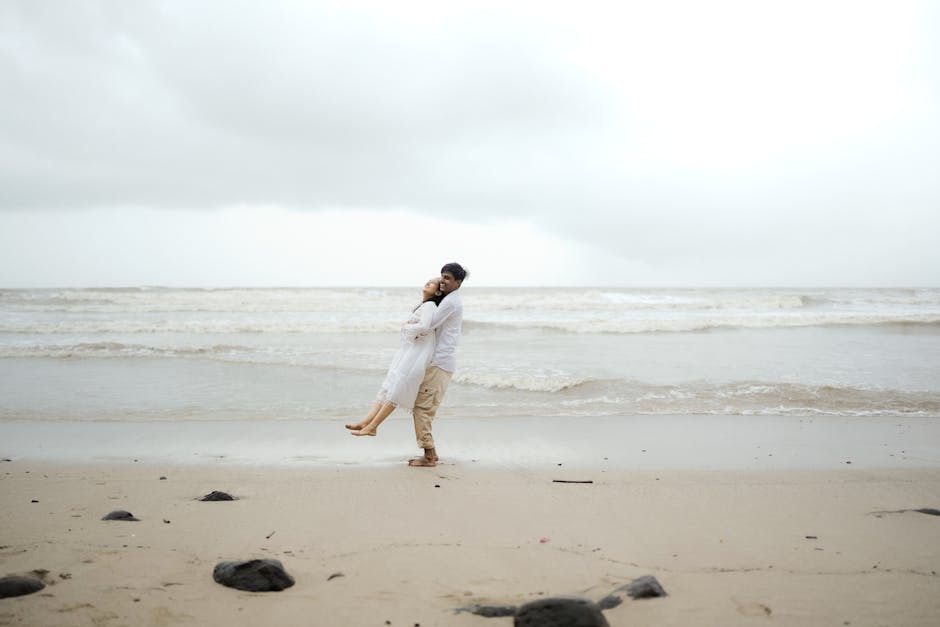 A romantic couple shares a loving moment on the serene Alibag beach in India.