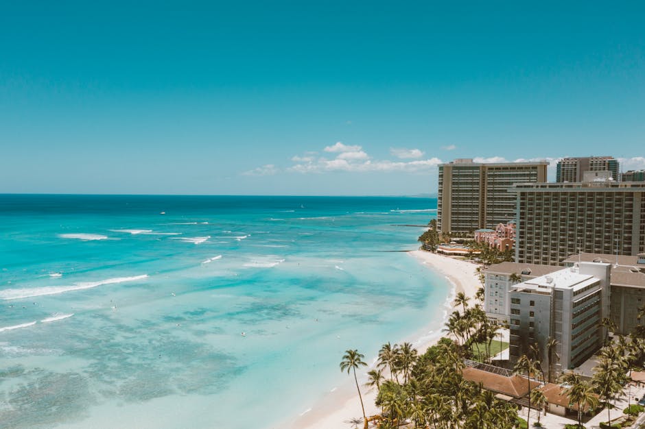 Breathtaking aerial shot of Waikiki Beach and Honolulu's skyline under a clear sky.