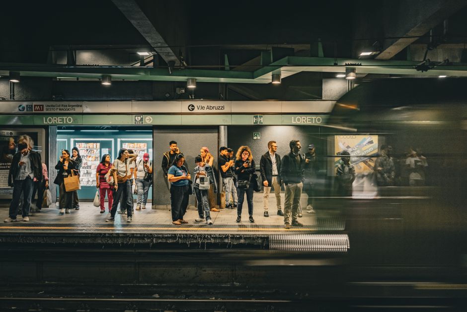 A bustling scene of commuters waiting for the train at Loreto Metro Station in Milan, Italy.