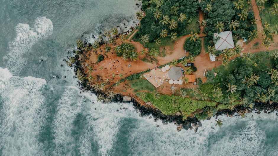 Discover the breathtaking aerial view of a lush, vibrant beach surrounded by vibrant ocean waves in Sri Lanka.
