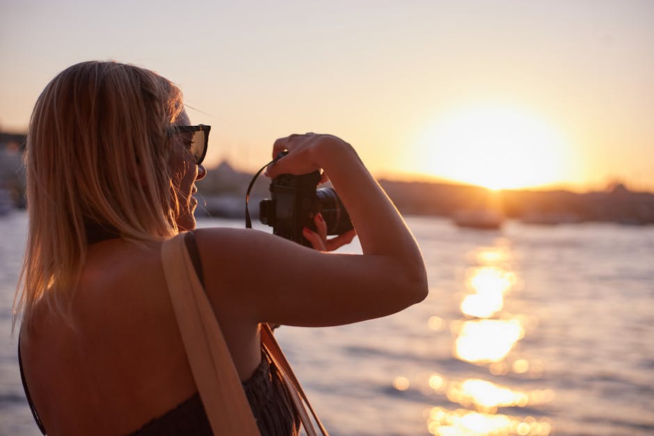 A woman photographing the sunset along the Bosphorus in İstanbul, portraying a serene moment.