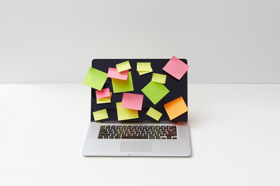Modern laptop covered with colorful sticky notes, showcasing creative organization and planning.